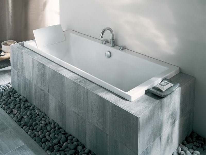 Une baignoire avec un tablier en carrelage sur-mesure gris foncé