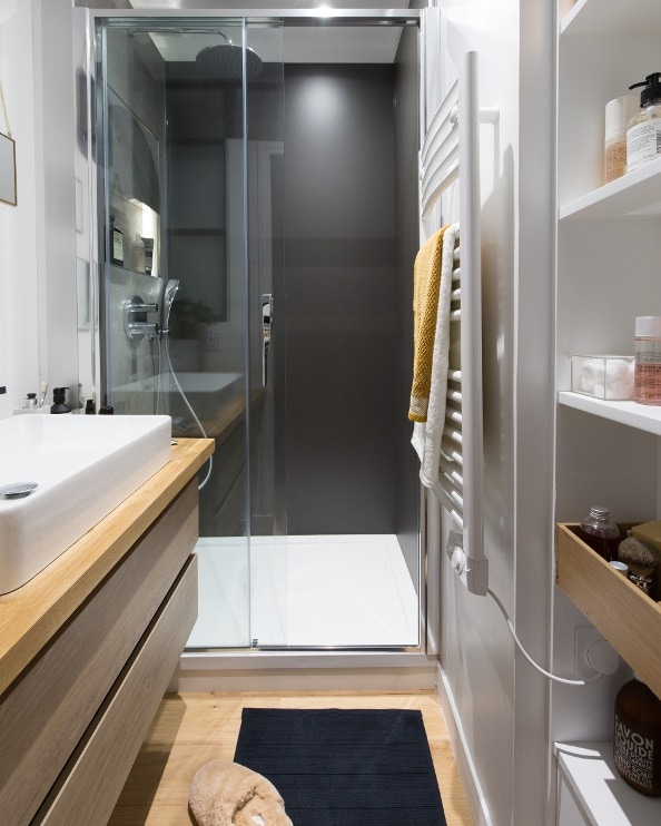 Une petite salle de bains en longueur avec de l'espace menant à la douche
